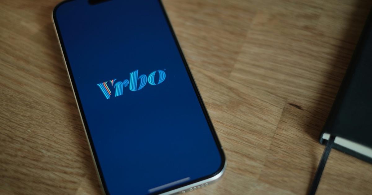 Vrbo app open on a phone resting on a wooden table